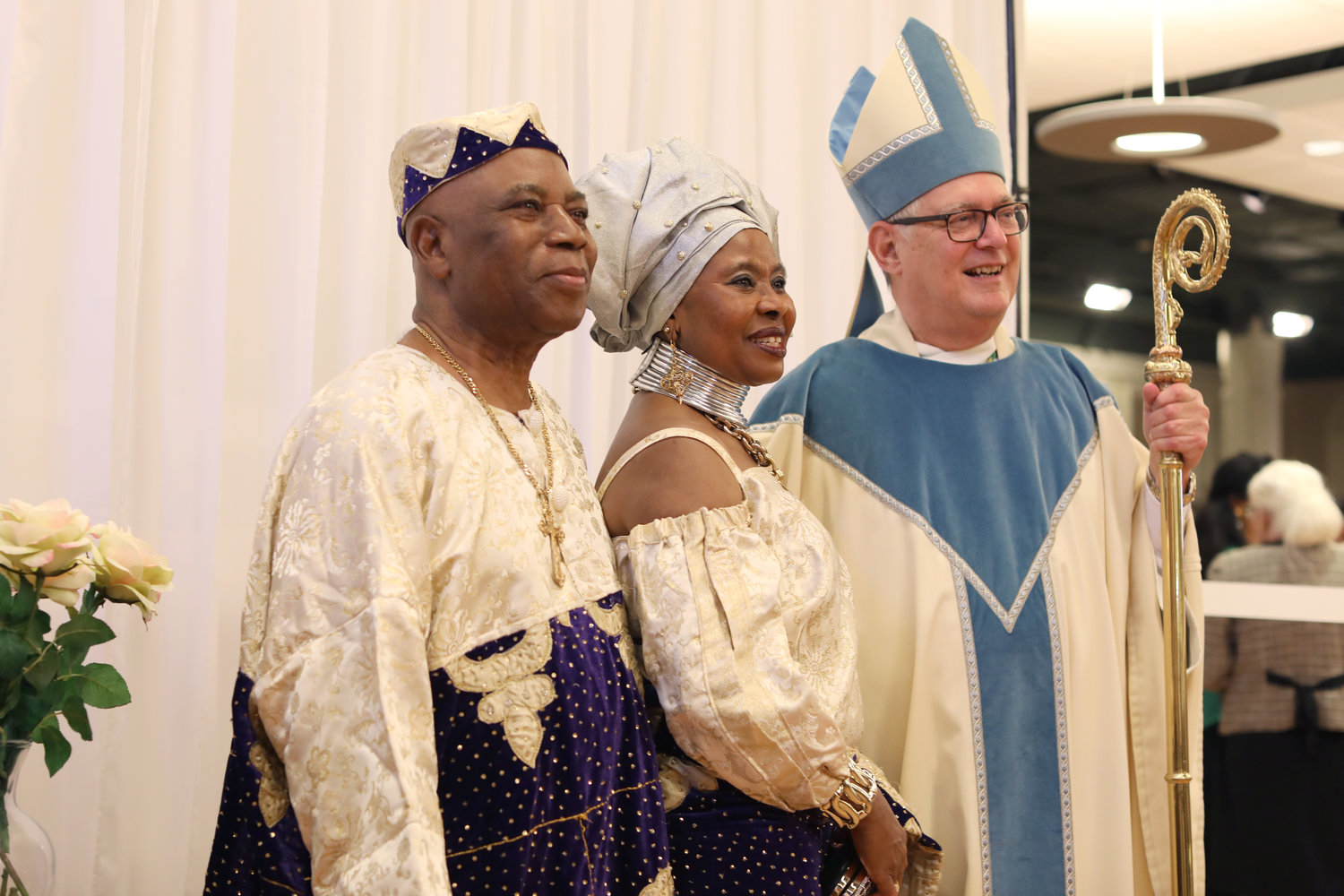 Celebrating 42 years of marriage, Augustina and Paschal Aguocha smile with Bishop Thomas J. Tobin after he offered Mass for couples celebrating wedding anniversaries.